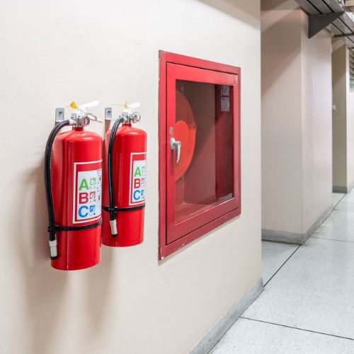 Fire and safety solutions with wall-mounted fire extinguishers and hose reel system installed in a commercial building by BuildMyInfra.